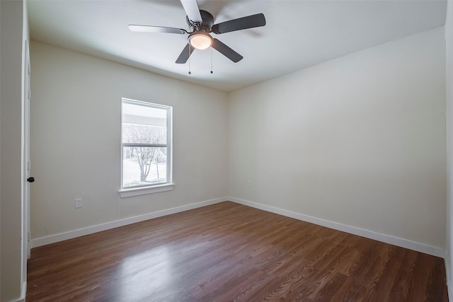 spare room featuring ceiling fan, baseboards, and dark wood finished floors