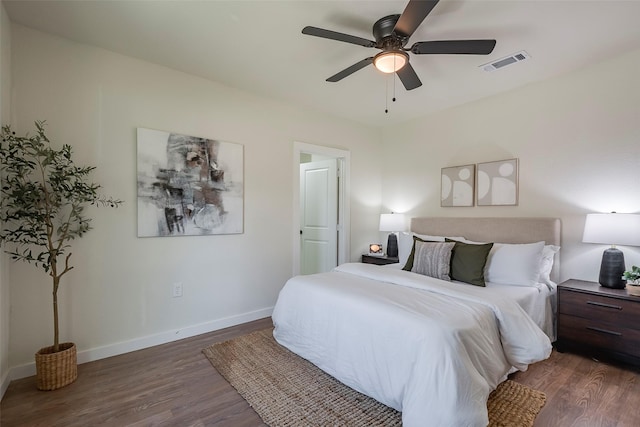 bedroom with visible vents, baseboards, wood finished floors, and a ceiling fan