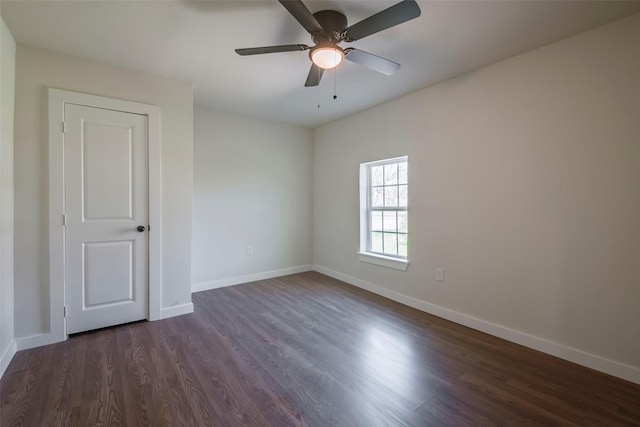 unfurnished room with baseboards, dark wood-type flooring, and a ceiling fan