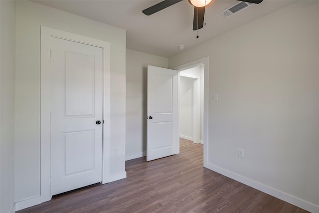 unfurnished bedroom featuring ceiling fan, dark wood-style floors, visible vents, and baseboards