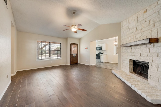 unfurnished living room featuring dark wood finished floors, a fireplace, vaulted ceiling, a textured ceiling, and ceiling fan