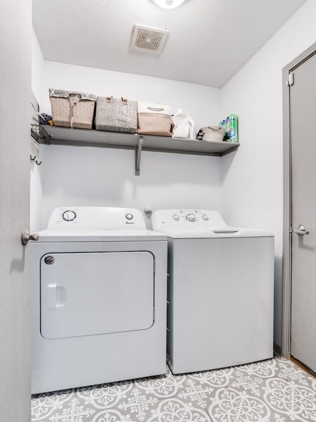 laundry room featuring laundry area, visible vents, and washer and clothes dryer