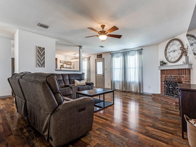 living room featuring visible vents, ceiling fan, wood finished floors, a textured ceiling, and a fireplace