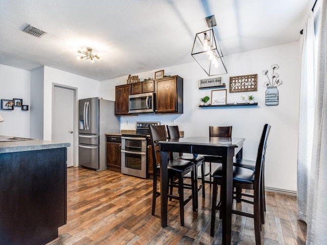 dining room featuring visible vents and wood finished floors