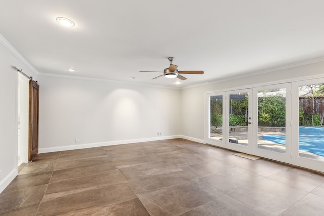 unfurnished room featuring baseboards, a barn door, a ceiling fan, and crown molding