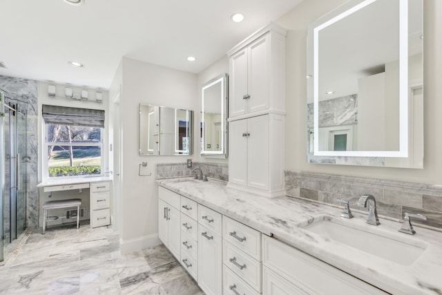 full bathroom with double vanity, marble finish floor, a sink, and a stall shower