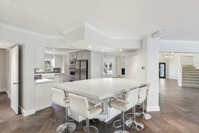 kitchen featuring baseboards, appliances with stainless steel finishes, a kitchen breakfast bar, ornamental molding, and light stone countertops