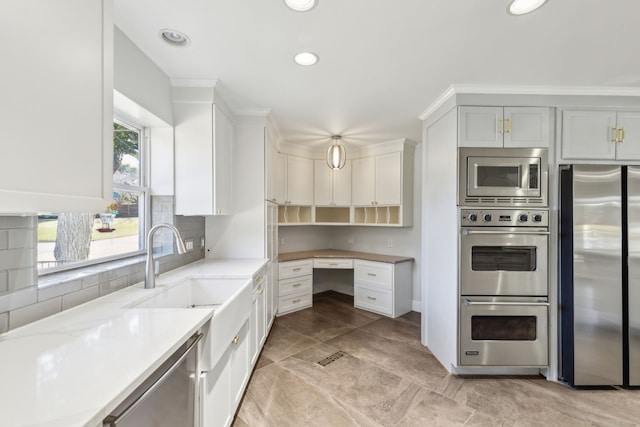 kitchen featuring decorative backsplash, light stone countertops, stainless steel appliances, a sink, and recessed lighting