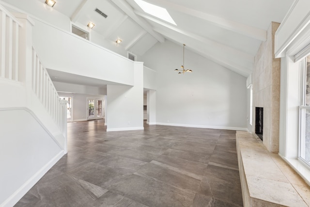 unfurnished living room with a skylight, visible vents, a fireplace, high vaulted ceiling, and beam ceiling