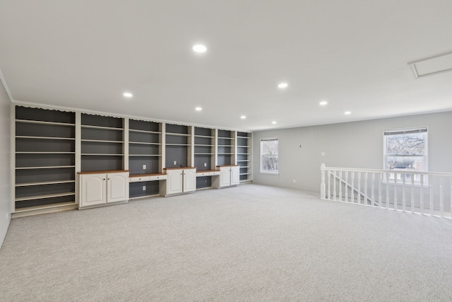 interior space featuring recessed lighting, light colored carpet, and built in desk