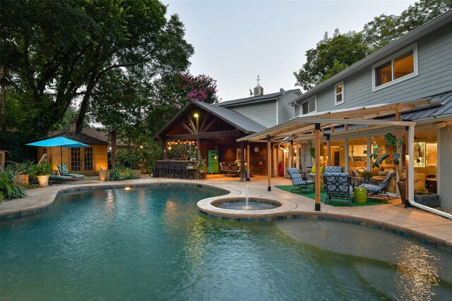 pool featuring french doors, a patio, outdoor dry bar, and an in ground hot tub