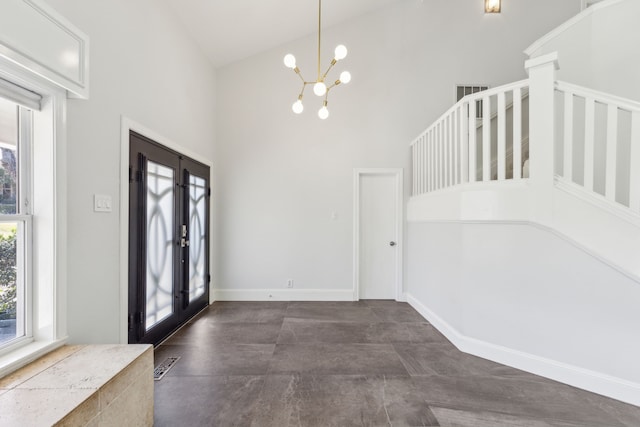 foyer entrance with baseboards, visible vents, a towering ceiling, stairs, and a chandelier