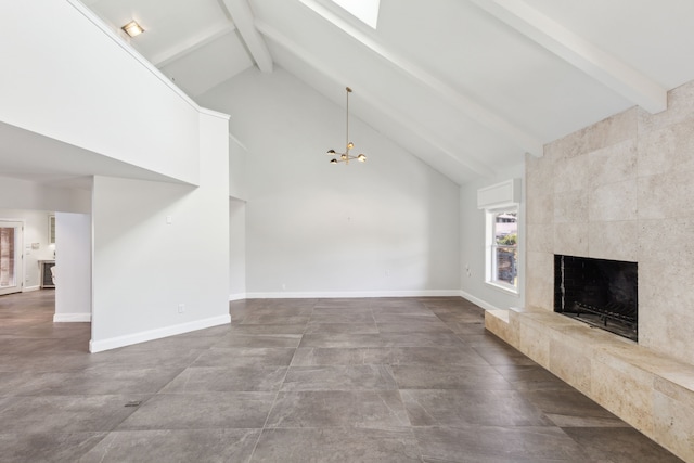 unfurnished living room with a chandelier, high vaulted ceiling, a fireplace, baseboards, and beam ceiling