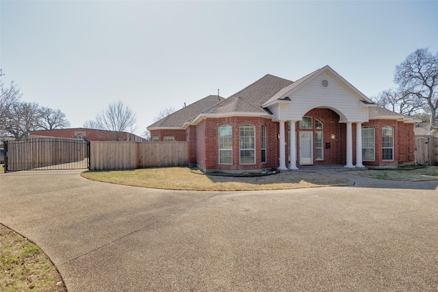 view of front of property featuring a gate, fence, and brick siding