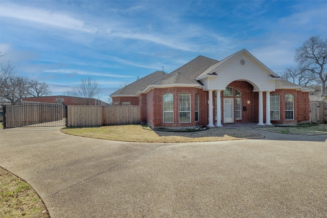 view of front facade featuring a gate, fence, and brick siding