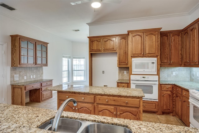 kitchen with white appliances, light tile patterned floors, visible vents, and a sink