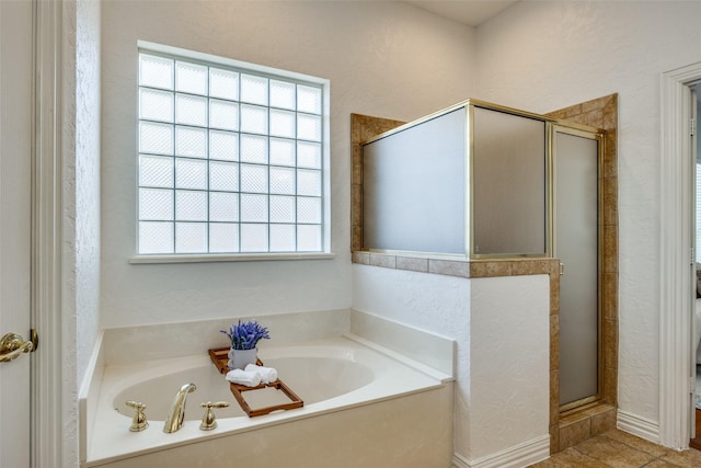 full bath featuring a textured wall, a stall shower, tile patterned flooring, and a bath