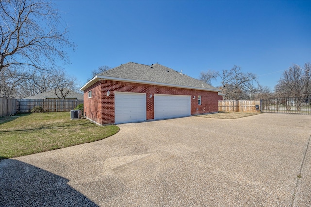 view of property exterior with central AC, brick siding, fence, a yard, and driveway