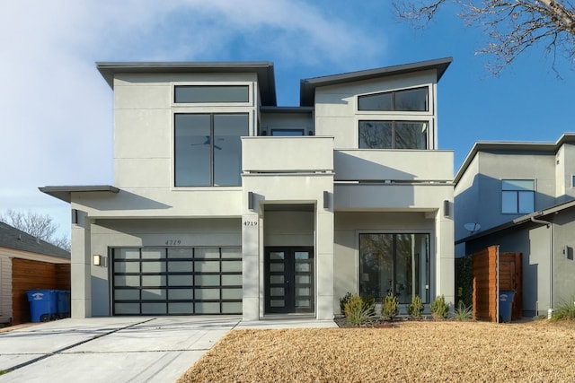 contemporary home with a garage, driveway, and stucco siding