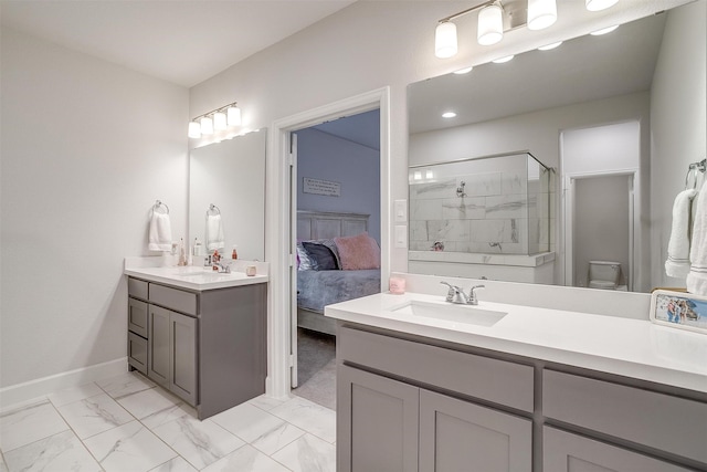 ensuite bathroom with a stall shower, baseboards, toilet, marble finish floor, and vanity