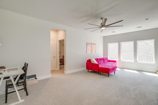 interior space with baseboards, a ceiling fan, visible vents, and light colored carpet