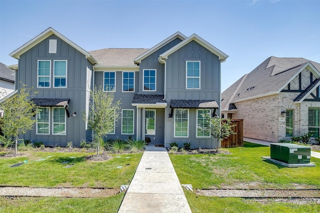 view of front of home featuring roof with shingles, board and batten siding, and a front yard