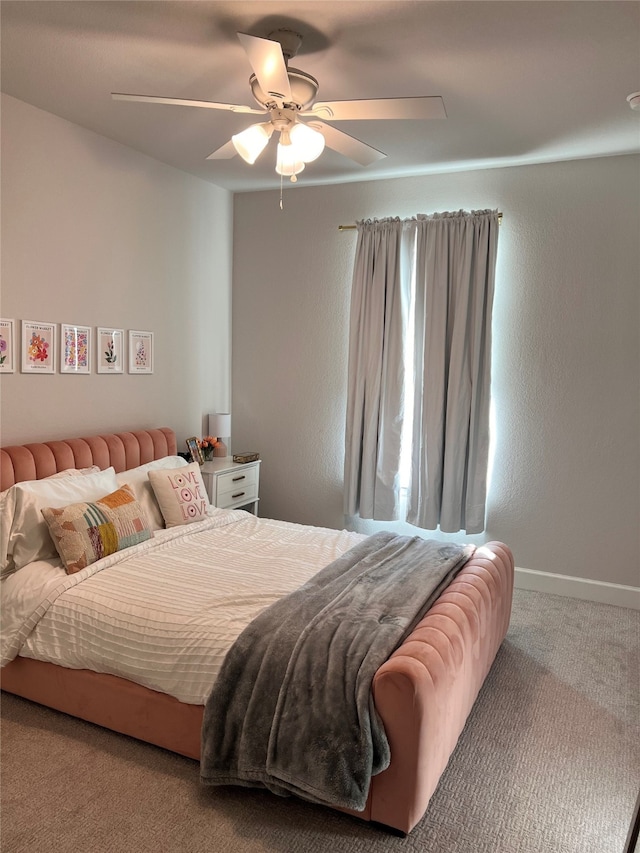 bedroom with a ceiling fan, carpet flooring, and baseboards