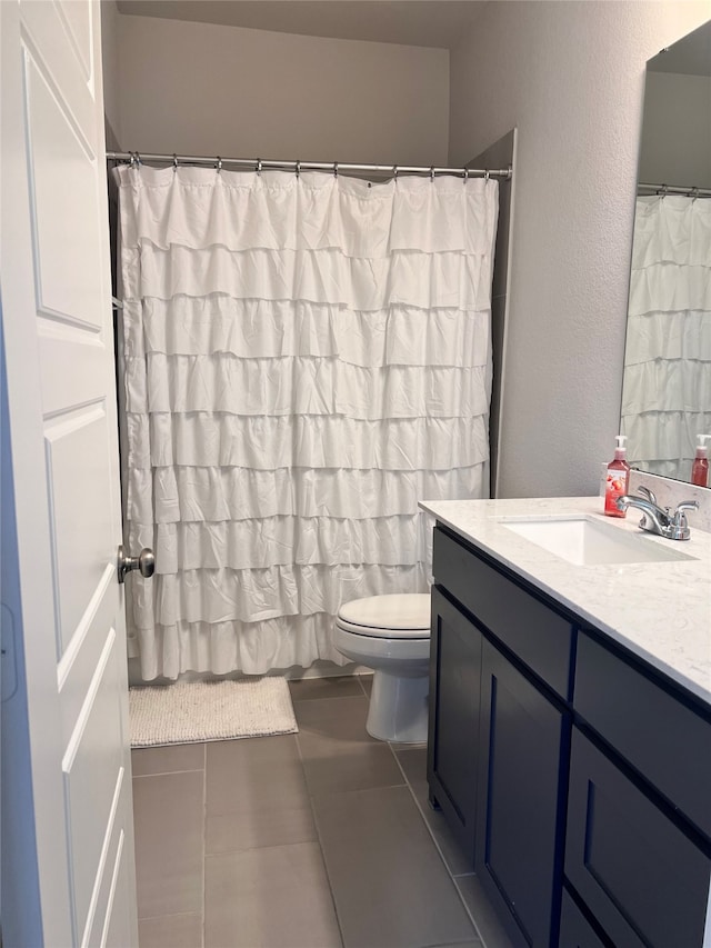 bathroom featuring toilet, tile patterned flooring, and vanity