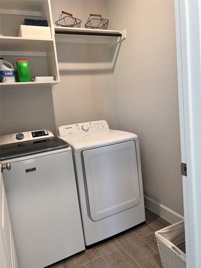 laundry room featuring laundry area, baseboards, washer and clothes dryer, and wood finished floors