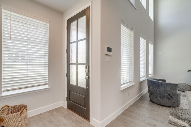 foyer featuring light wood-style flooring and baseboards