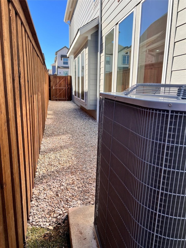 view of side of property featuring central AC and fence