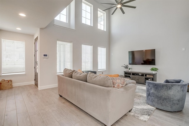 living area with baseboards, ceiling fan, recessed lighting, and light wood-style floors