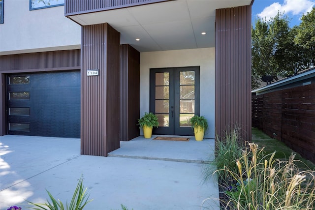 doorway to property with driveway, french doors, and an attached garage