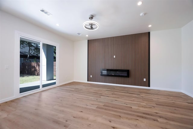 unfurnished living room with recessed lighting, visible vents, baseboards, and wood finished floors