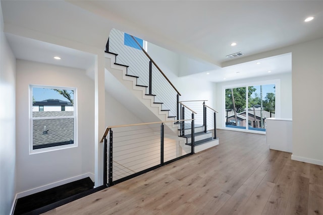 stairway featuring recessed lighting, visible vents, baseboards, and wood finished floors