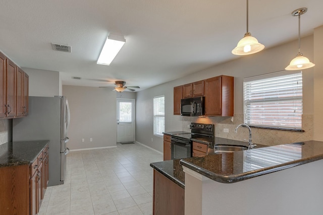 kitchen with visible vents, decorative backsplash, brown cabinetry, a sink, and black appliances