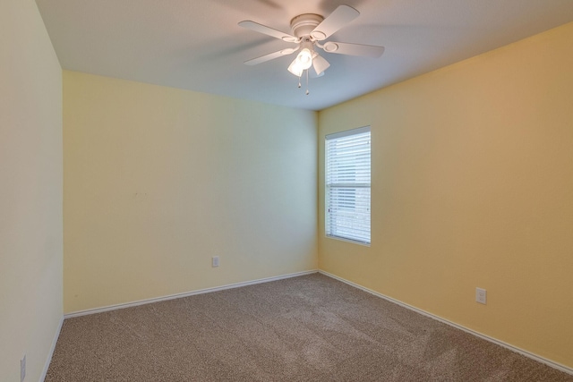 carpeted empty room with ceiling fan and baseboards