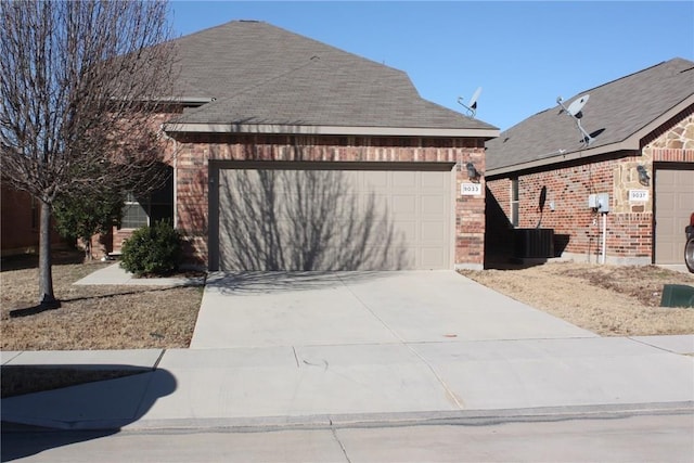 exterior space with a garage, driveway, brick siding, and roof with shingles