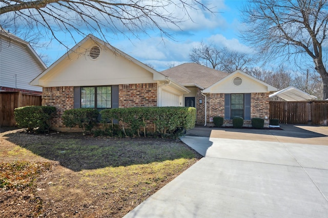 ranch-style home featuring brick siding, an attached garage, and fence