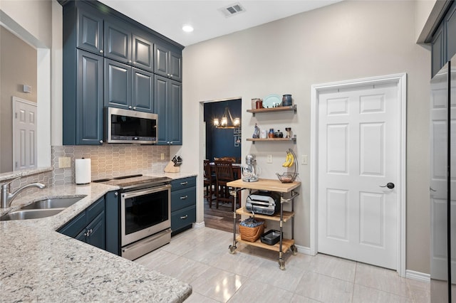 kitchen with stainless steel appliances, visible vents, backsplash, a sink, and light stone countertops