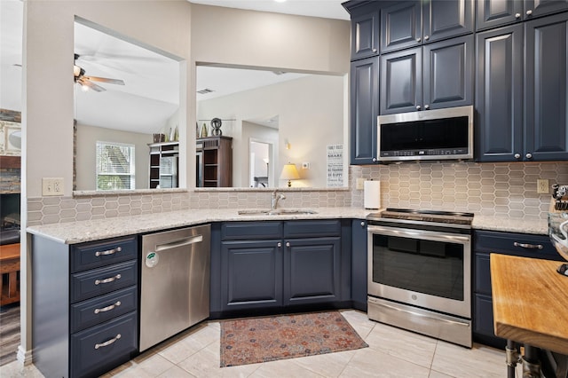 kitchen with tasteful backsplash, ceiling fan, blue cabinets, stainless steel appliances, and a sink