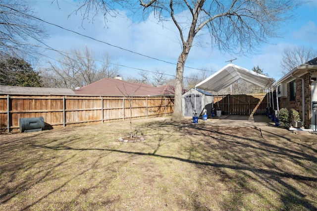 view of yard featuring an outbuilding, a patio area, a fenced backyard, and a storage unit