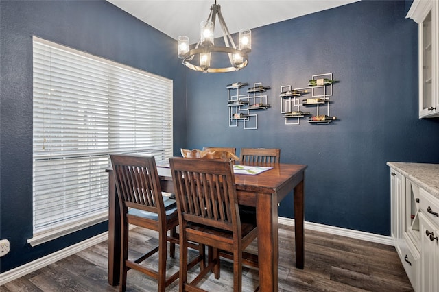 dining room with a notable chandelier, dark wood finished floors, and baseboards