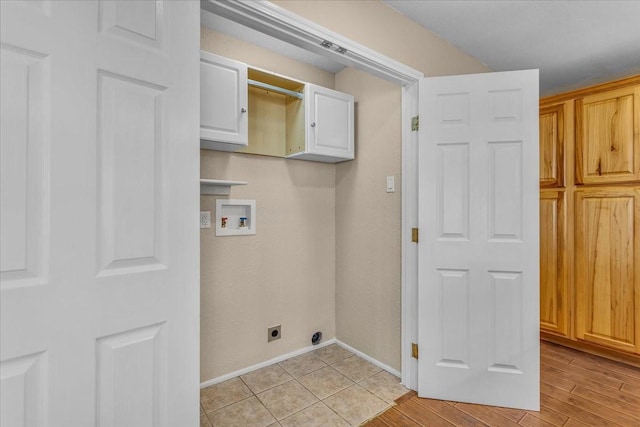 washroom with hookup for a washing machine, hookup for an electric dryer, baseboards, light wood-type flooring, and cabinet space