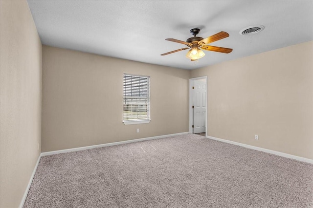 spare room featuring baseboards, visible vents, ceiling fan, and carpet flooring