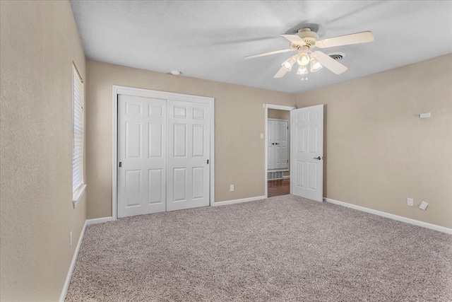 unfurnished bedroom with visible vents, baseboards, a ceiling fan, carpet flooring, and a closet