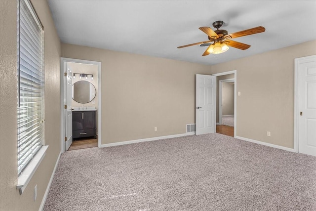 unfurnished bedroom with carpet, visible vents, baseboards, and ensuite bathroom