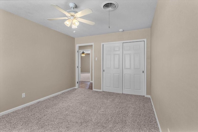 unfurnished bedroom featuring carpet, visible vents, baseboards, and a closet