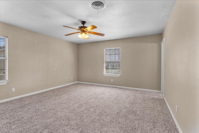 carpeted spare room featuring a textured ceiling, a ceiling fan, visible vents, and baseboards