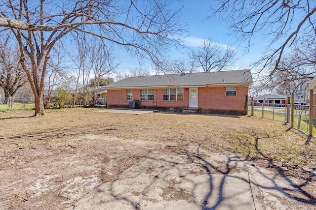 view of front of house featuring brick siding and fence